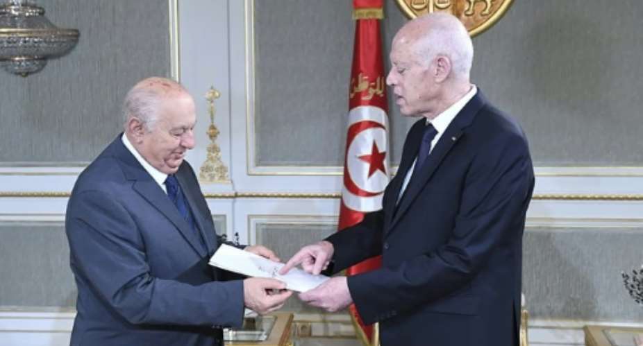 Sadeq Belaid hands a draft of the new constitution to President Kais Saied R at the Carthage Palace in Tunis on June 20 last month.  By - Tunisian PresidencyAFPFile