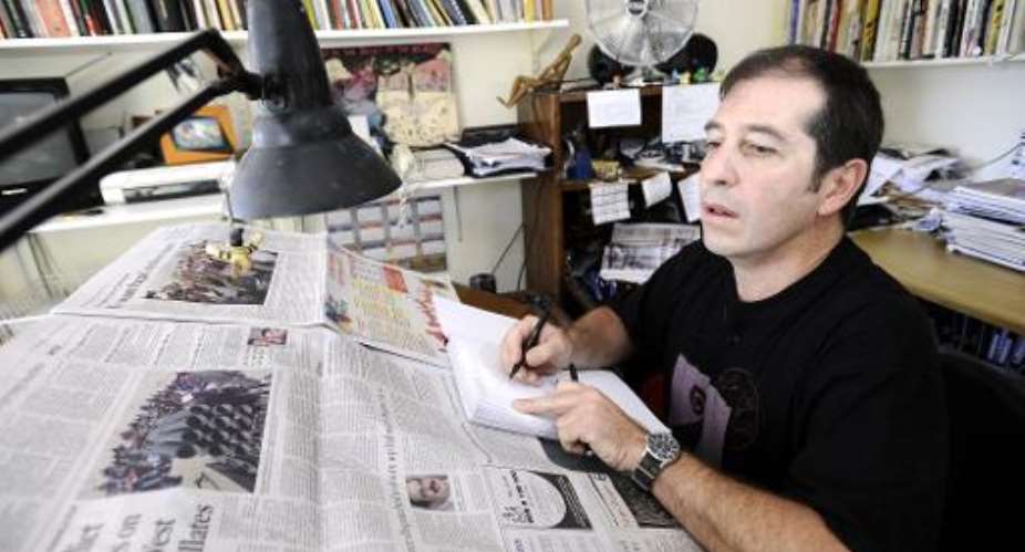 Political cartoonist Jonathan Shapiro, better known as Zapiro, works at his home in Cape Town, South Africa, on March 15, 2011.  By Stephane de Sakutin AFPFile
