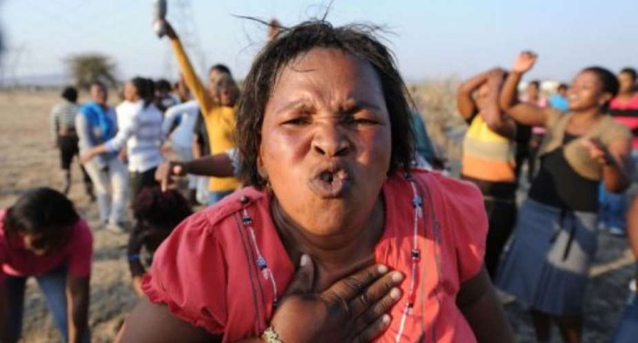 Women sing, dance and protest at the scene where 34 people died after police opened fire on striking mineworkers.  By  AFP