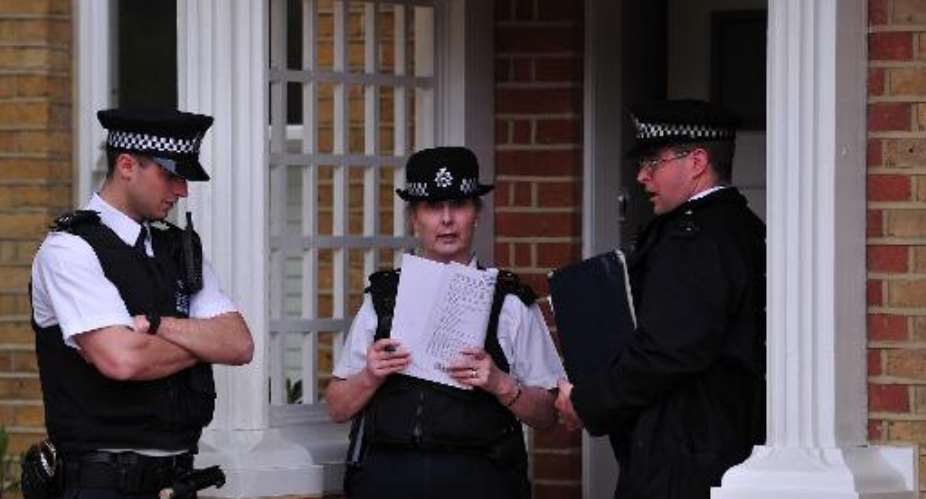 Police officers stand outside a house in New Malden, south London, on April 23, 2014 after three children were found dead at the house on the previous day.  By Carl Court AFP