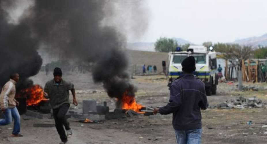 Striking miners flee South African police in Marikana.  By Alexander Joe AFP