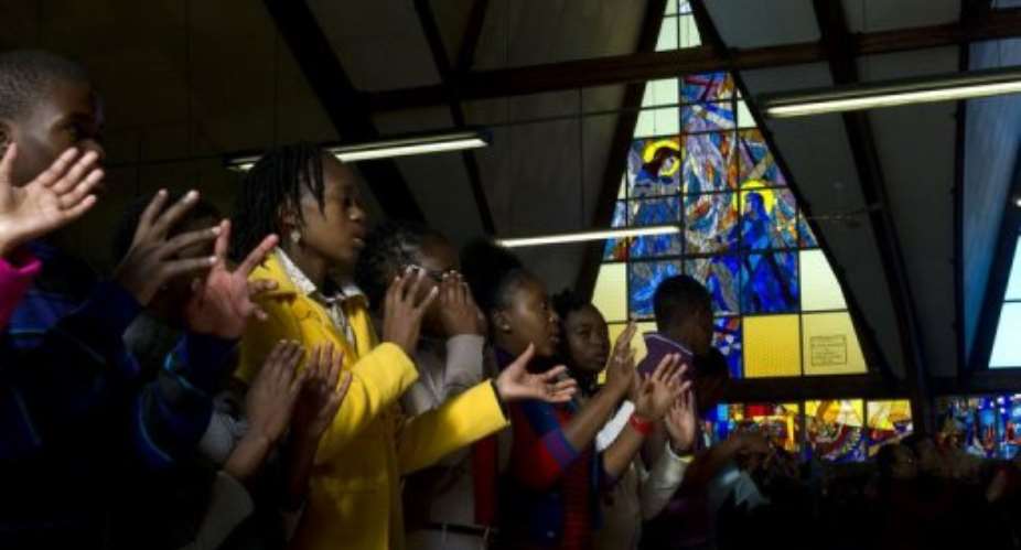 The congregation at the Regina Mundi Catholic Church in Soweto pray on June 9, 2013, for Nelson Mandela.  By Alexander Joe AFP