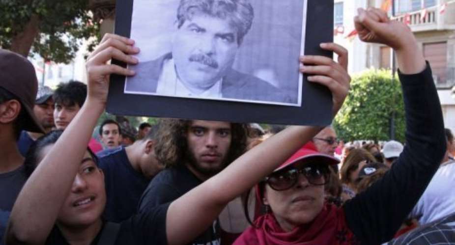 Tunisians hold a portrait of slain opposition politician Mohamed Brahmi on July 25, 2013.  By Khalil AFP