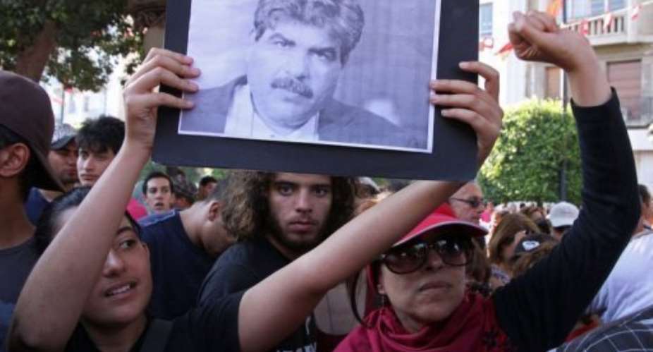 Tunisians hold a portrait of slain opposition politician Mohamed Brahmi on July 25, 2013.  By Khalil (AFP)