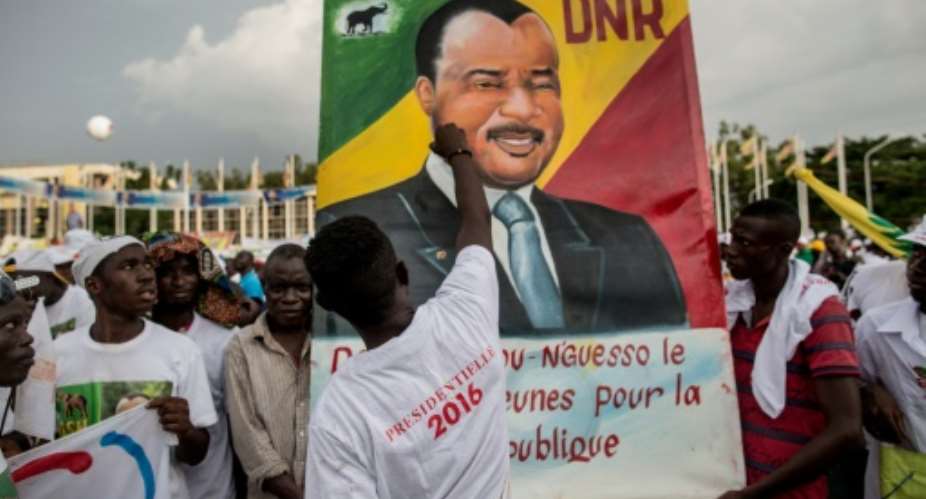 A man puts the last touches to a painting of incumbent Congolese President Denis Sassou Nguesso at the closing rally of his electoral campaign in Brazzaville.  By Marco Longari (AFP)