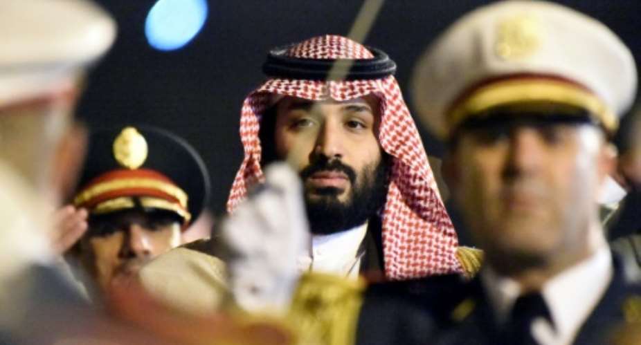 Saudi Crown Prince Mohammed bin Salman is seen behind a military band upon his arrival at Algiers International Airport, southeast of the capital Algiers on December 2, 2018.  By RYAD KRAMDI (AFP)
