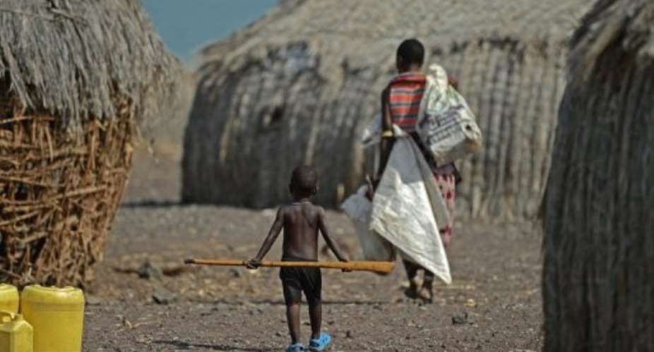 A mother and child walk in the village of Komote on the shores of Lake Turkana, northern Kenya on May 18, 2012.  By Carl de Souza AFPFile