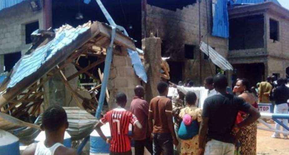 Bystanders look at the Sharon Church after it was struck by a suicide bomber in Kaduna.  By Victor Ulasi (AFP)