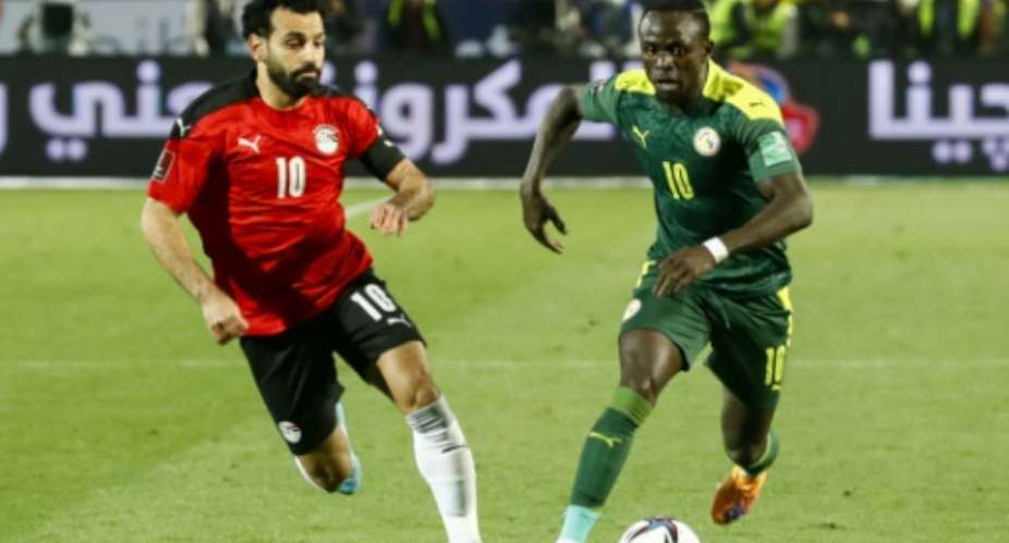 Senegal star Sadio Mane R is chased by Liverpool teammate and Egypt captain Mohamed Salah L during a 2022 World Cup play-off in Cairo.  By Khaled DESOUKI AFPFile