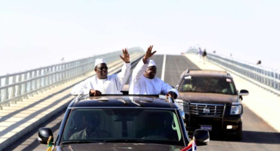 Senegal's president Macky Sall L and Gambian President Adama Barrow R wave as they inaugurate the Senegambia Bridge built to facilitate trade and travel in this part of West Africa.  By SEYLLOU AFP