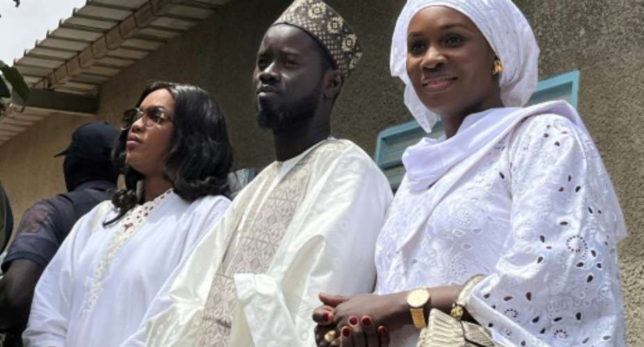 Senegal's president-elect Bassirou Diomaye Faye C with his wives Marie Khone Faye L and Absa Faye R.  By Khadidiatou Sene AFP