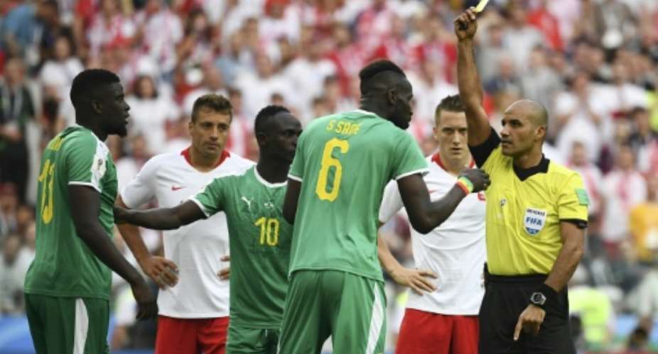 Senegal's Salif Sane C reacts as he receives a yellow card by referee Nawaf Abdullah Ghayyath Shukralla during their Russia 2018 World Cup Group H match against Poland, at the Spartak Stadium in Moscow, on June 19.  By FRANCK FIFE AFPFile