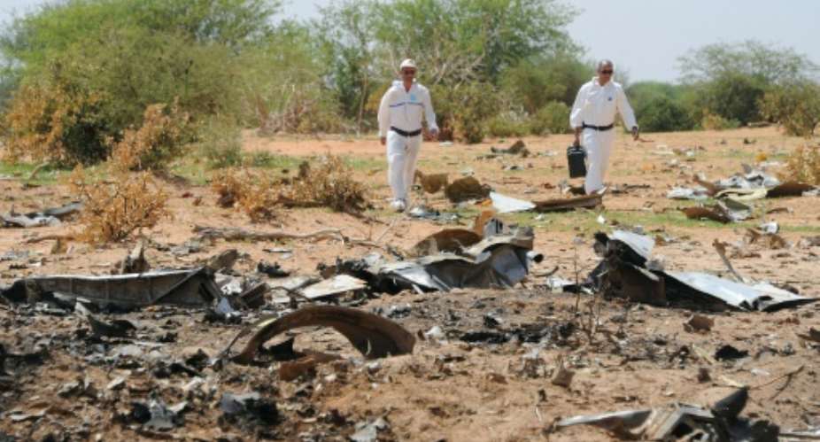 Forensics gather evidence at the crash site of the Air Algerie flight AH5017 in Mali's Gossi region on July 29, 2014.  By Sia Kambou AFPFile