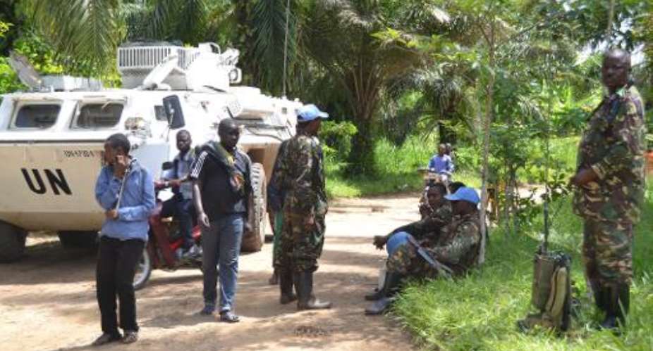 UN peacekeepers of the MONUSCO force stand next to a UN vehicle, after the bodies of seven people were found on May 9, 2015 in Matembo, in the Democratic Republic of Congo's North-Kivu province.  By Kudra Maliro AFP