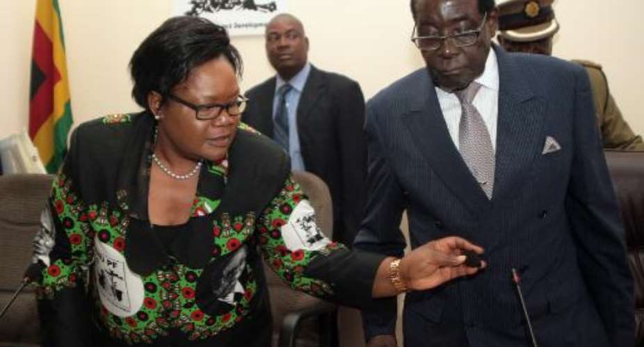 Zimbabwean President Robert Mugabe R and then Vice-President Joice Mujuru pictured at a meeting of the ruling ZANU-PF party headquarters in Harare in October 2014.  By Jekesai Njikizana AFPFile