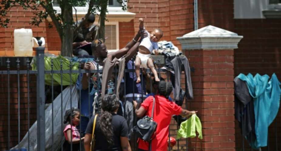Several hundred asylum-seekers scaled the iron railings of the  United Nations High Commissioner for Refugees office in Pretoria seeking protection.  By Phill Magakoe AFP