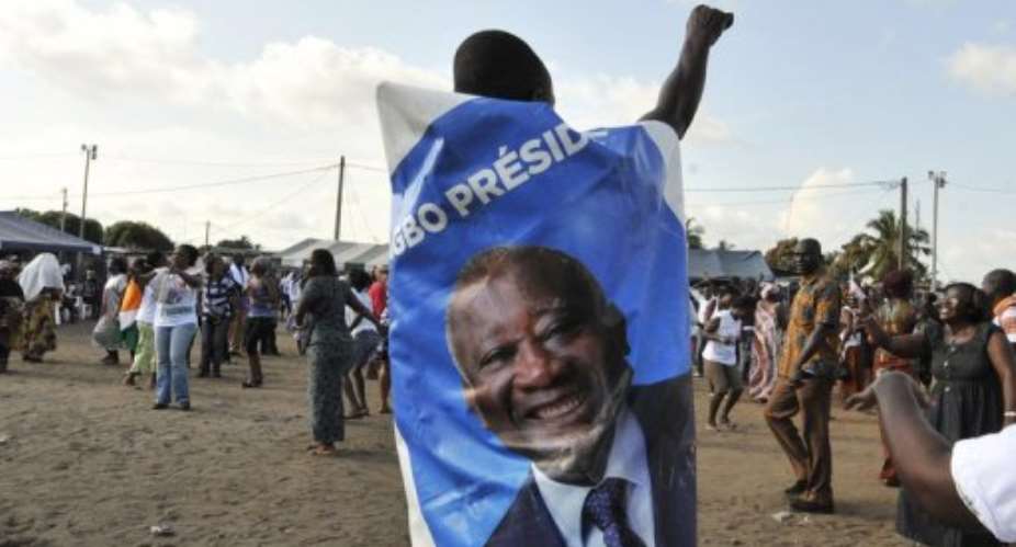 A supporter of the Ivorian Popular Front wears a banner with a photo of former Ivory Coast strongman Laurent Gbagbo.  By Sia Kambou AFPFile