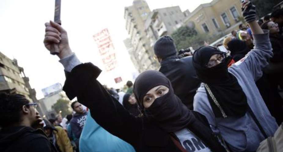 A protester in Cairo on February 6, 2013 holds up a knife during a demonstration to demand an end to sexual violence against women.  By  AFPFile