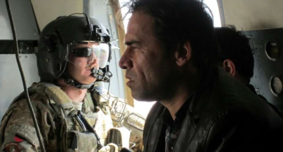 Shah Marai sits in a helicopter with a member of the International Security Assistance Force (ISAF) while on assignment in Afghanistan in 2013.  By Ben Sheppard (AFP/File)