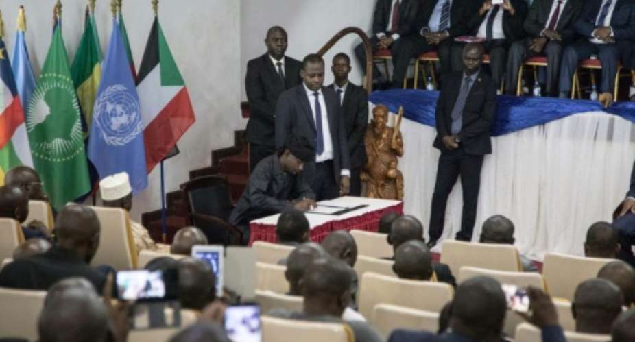 Sidiki Abbas, leader of the 3R armed group claiming to defend the Fulani people, signs the so-called Khartoum Agreement on Wednesday.  By FLORENT VERGNES, FLORENT VERGNES (AFP)