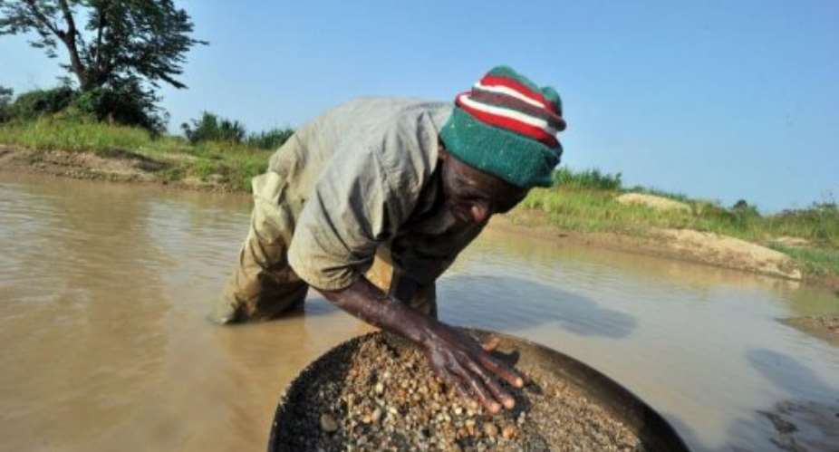 A diamond prospector filters earth from a river in April in Koidu.  By Issouf Sanogo AFPFile