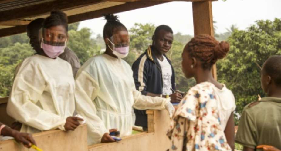 File picture shows Sierra Leone health officials checking passengers transiting at the border crossing with Liberia in Jendema.  By Zoom Dosso (AFP/File)