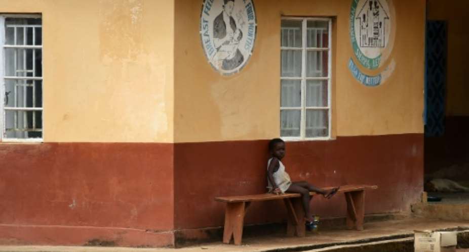 A child under quarantine sits outside a health center in Lokomasama, the biggest chiefdom in Sierra Leone's Port Loko province, on November 8, 2014.  By Francisco Leong AFPFile