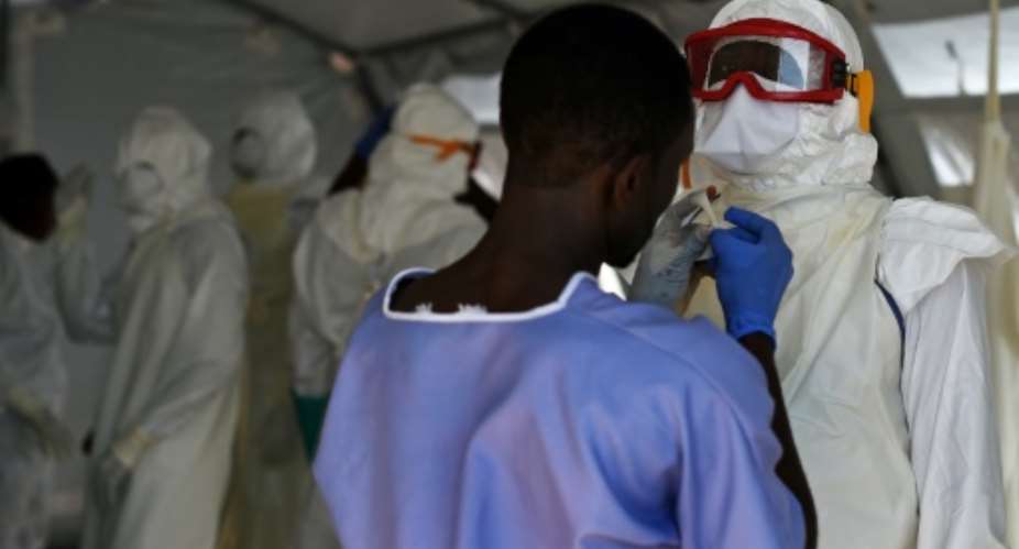 Health workers put on their personal protective equipment in the Kenama treatment centre run by the Red Cross Society on November 15, 2014 in Kenema, Sierra Leone.  By Francisco Leong AFPFile