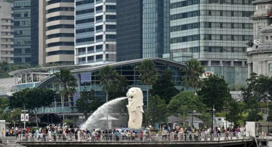 Tourists gather on a jetty around the Merlion next to the financial business district in Singapore on October 31, 2014.  By Roslan Rahman AFPFile
