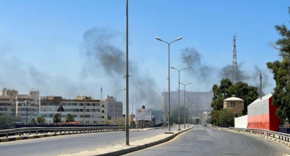 Smoke billows as rival Libyan groups exchange fire in the capital Tripoli.  By Mahmud TURKIA AFP
