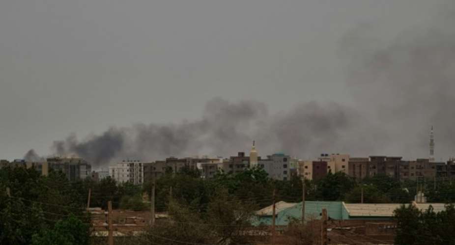 Smoke billows behind buildings in Khartoum as fighting between Sudan's warring generals intensified.  By - AFP