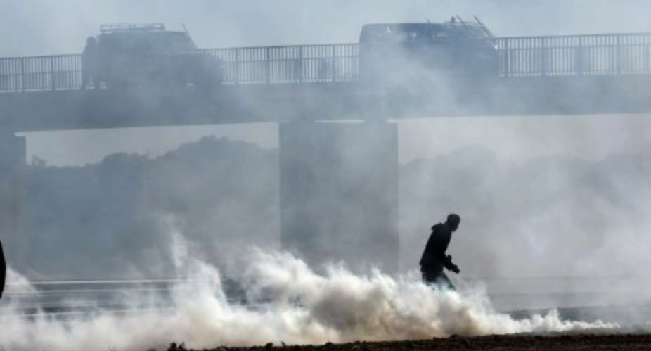 Smoke billows from tear gas fired by Tunisian security forces in the town of Agareb on November 11, 2021, two days after the death of a protester during angry demonstrations over the reopening of a rubbish dump.  By ANIS MILI AFP