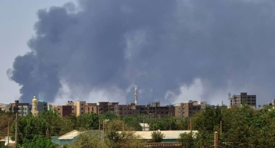 Smoke billows over buildings in Khartoum during the third week of battles between rival generals.  By - (AFP)