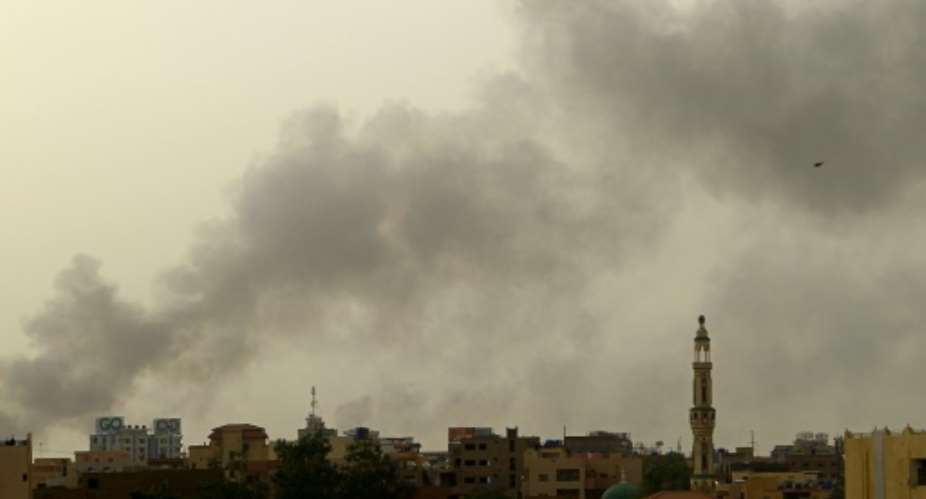 Smoke rises above buildings in southern Khartoum before a ceasefire brokered by the United States and Saudi Arabia was due to expire.  By - AFP