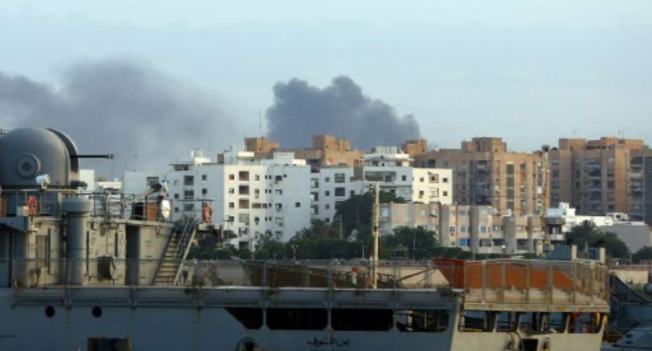 Smoke rises in the centre of the Libyan capital of Tripoli after deadly clashes on May 26, 2017 between forces loyal to the UN-backed unity government and rival militiamen.  By MAHMUD TURKIA AFP
