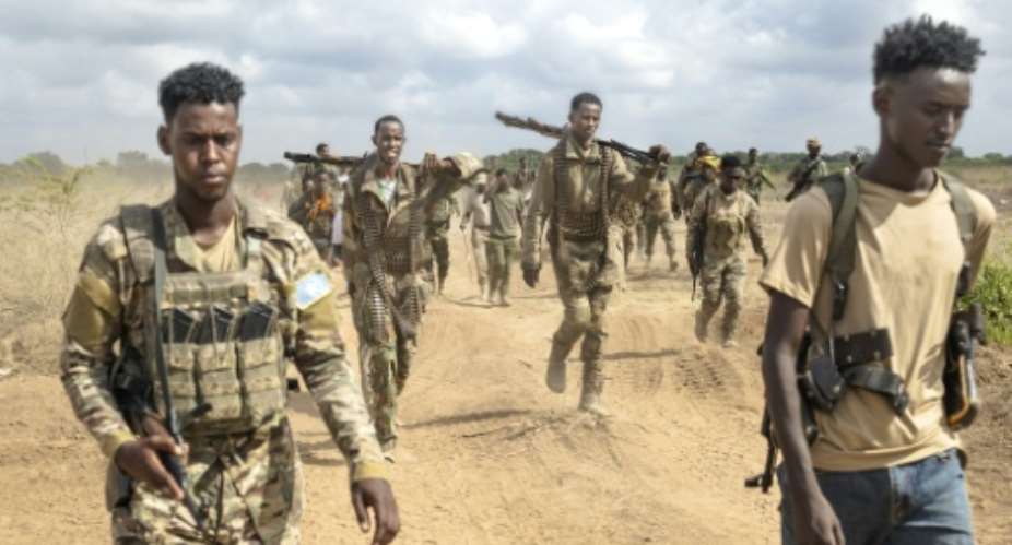 Soldiers of the Somali National Army (SNA) walk near the front line.  By Tony KARUMBA (AFP)