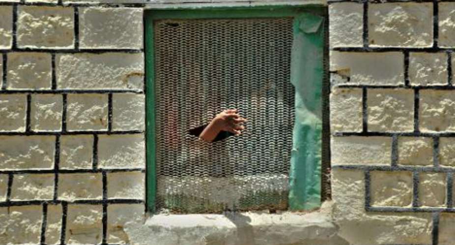 File picture taken on March 30, 2011 shows an inmate pushing his hand out through a hole on a window grille at the Berbera prison in Somalia's breakaway republic of Somaliland.  By Tony Karumba AFPFile