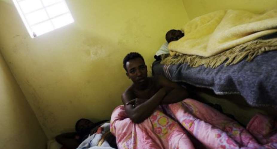 Sick Somali foreign nationals lay cramped in a toilet at a refugee camp in Soetwater, S. Africa, on June 18, 2008.  By Gianluigi Guercia AFPFile