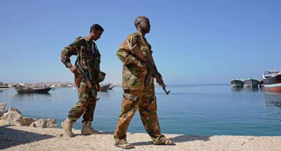 Somali soldiers walk along Bosaso harbor in Puntland on November 18, 2013.  By Mohamed Abdiwahab AFPFile