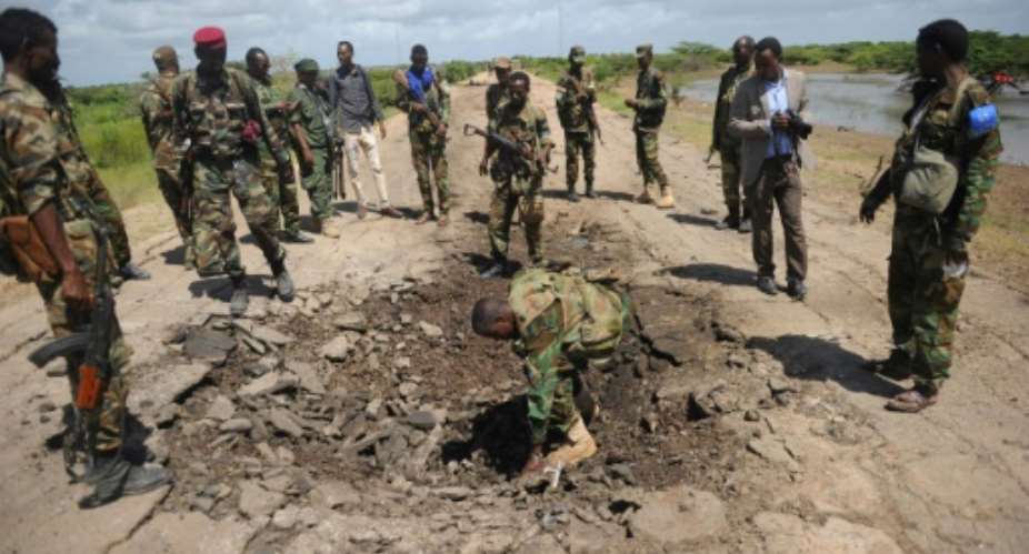 Somali soldiers look at the site of a car bomb blast near where an American special operations soldier was killed in southern Somalia in June 2018.  By Mohamed ABDIWAHAB AFPFile