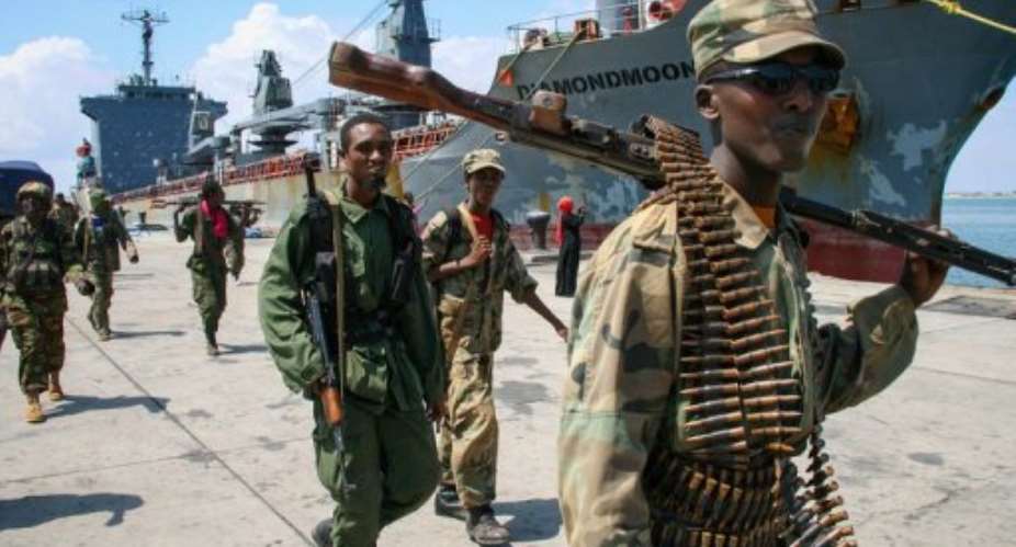 Somali soldiers walk past a ship docked in Kismayo port on November 2, 2012.  By Ade Clewlow (African Union-United Nations Information Support Team /AFP/File)