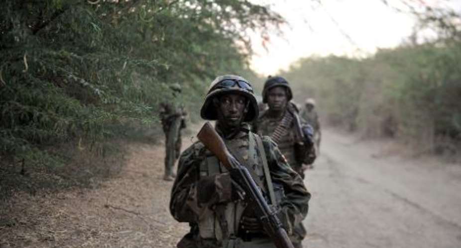 Ugandan soldiers of the African Union Mission in Somalia take a break as they march toward the town of Qoryooley, on March 22, 2014, during an offensive to take the town back from Shebab militants.  By Tobin Jones AU UN Information Support teamAFPFile