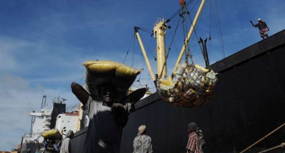 A Somalian porter carries a sack on April 24, 2013 in the sea port in Mogadishu.  By Tony Karumba AFPFile