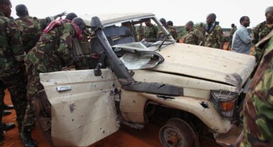 A picture released on August 22, 2013 show AMISOM troops inspecting a destroyed Shebab vehicle at Kismayo Airport.  By Ramadaan Mohamed (AU UN IST/AFP)
