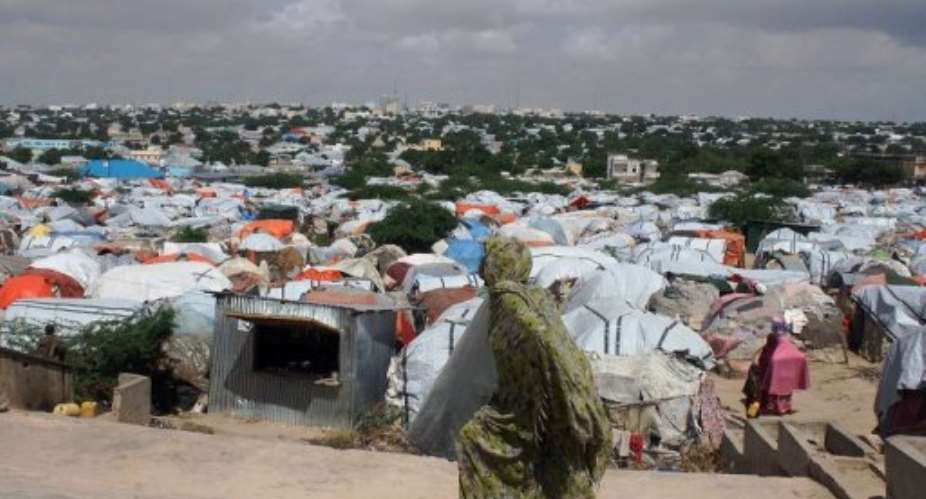 A Somali refugee walks in front of a camp for internally displaced people in Mogadishu on December 4, 2012.  By Abdurashid Abdulle AFPFile