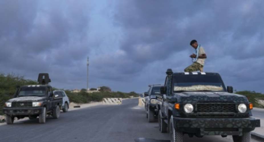 Somalian security officers pray at a security checkpoint on the outskirts of Mogadishu.  By Tony KARUMBA (AFP)