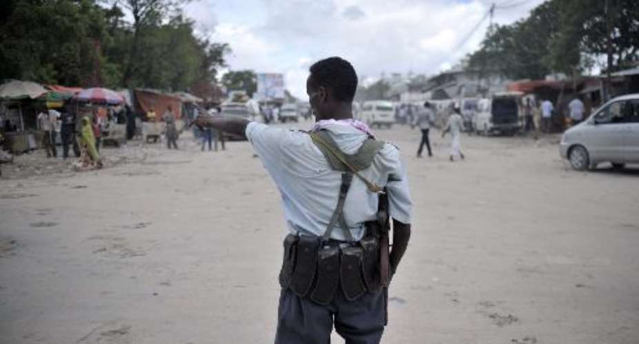 An AU-UN IST picture shows a Somali policeman directing traffic at a checkpoint in downtown Mogadishu, May 3, 2013.  By  AU UN IST PHOTOAFPArchives