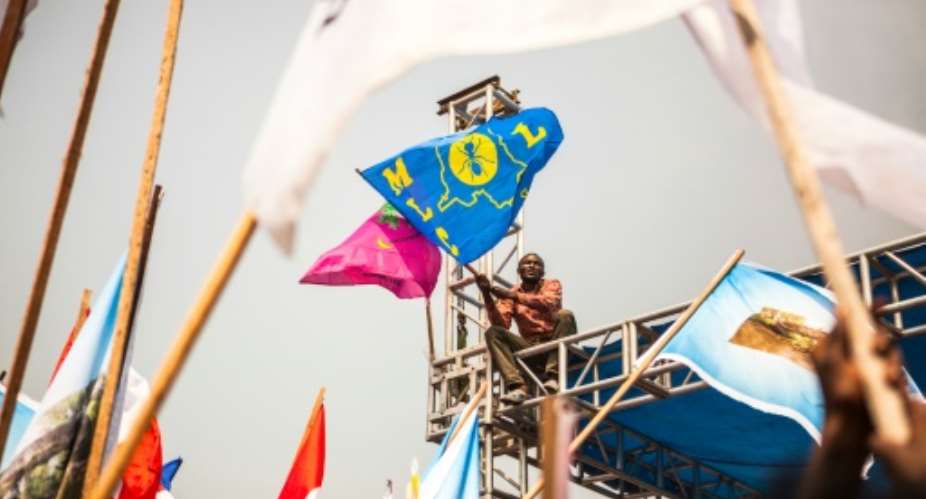A demonstrator waves a party's flag of the Movement for the Liberation of the Congo MLC, during a rally in support of Congolese President Joseph Kabila in Kinshasa, on July 29, 2016.  By Eduardo Soteras AFP