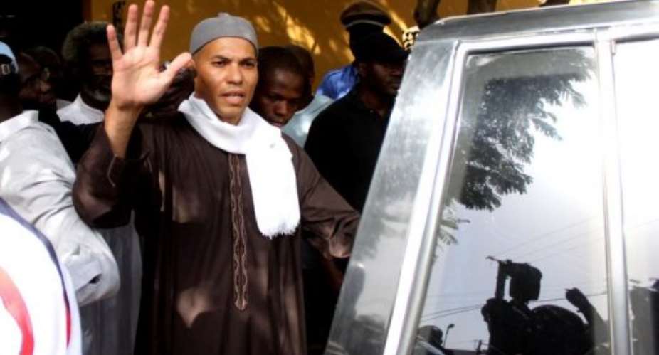 Karim Wade, the son of former Senegalese leader Abdoulaye Wade, waves while being arrested on April 15, 2013, in Dakar.  By  (AFP/File)