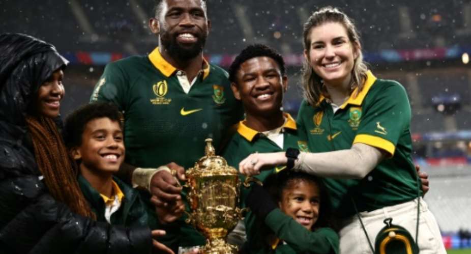 South Africa and captain Siya Kolisi (3rd L) and his wife Rachel Kolisi (R) pose for a photo with their family after South Africa won the World Cup Final in Paris in 2023.  By Anne-Christine POUJOULAT (AFP/File)